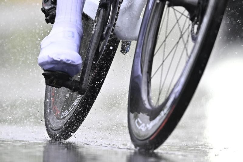 Ein Radfahrer fährt bei Regen über eine Straße (Symbolbild): Am Wochenende soll der Dauerregen nachlassen.