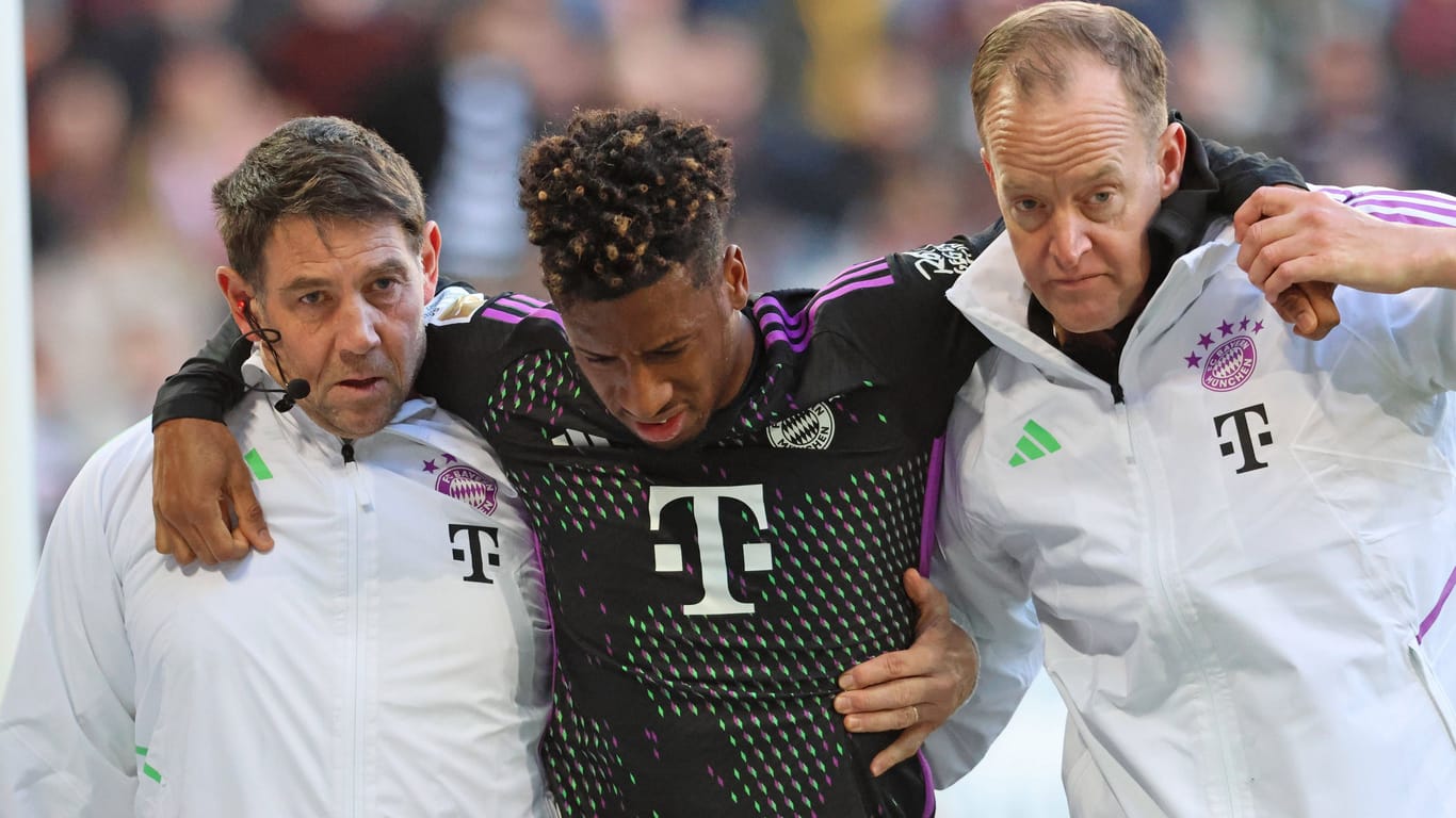 Trauriger Abgang: Kingsley Coman muss im Spiel in Augsburg mit Hilfe der Bayern-Betreuer vom Platz.