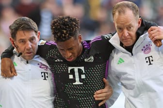 Trauriger Abgang: Kingsley Coman muss im Spiel in Augsburg mit Hilfe der Bayern-Betreuer vom Platz.