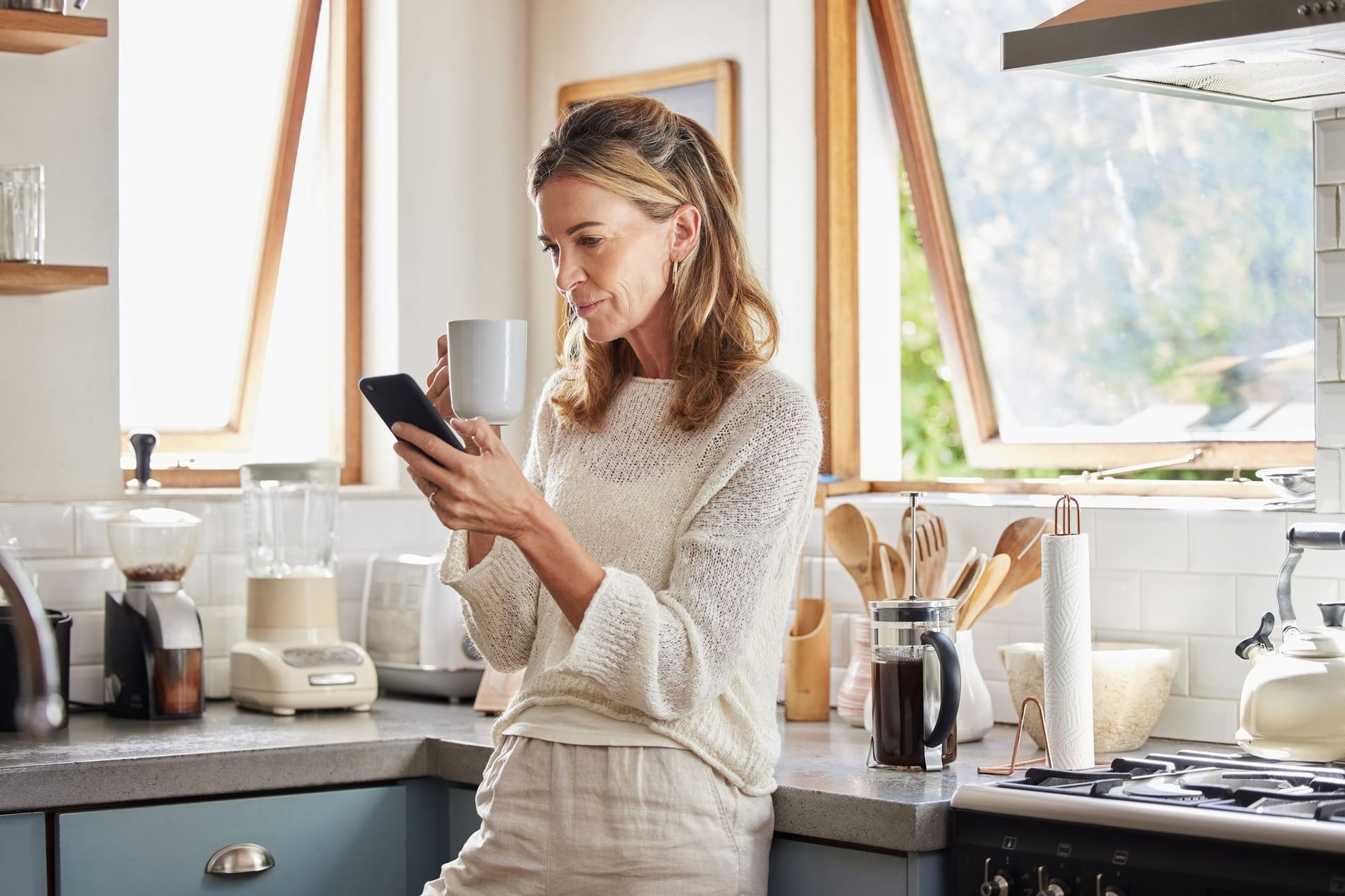 Frau blickt auf ihr Handy. Bis zum Rente fehlen noch einige Jahre.