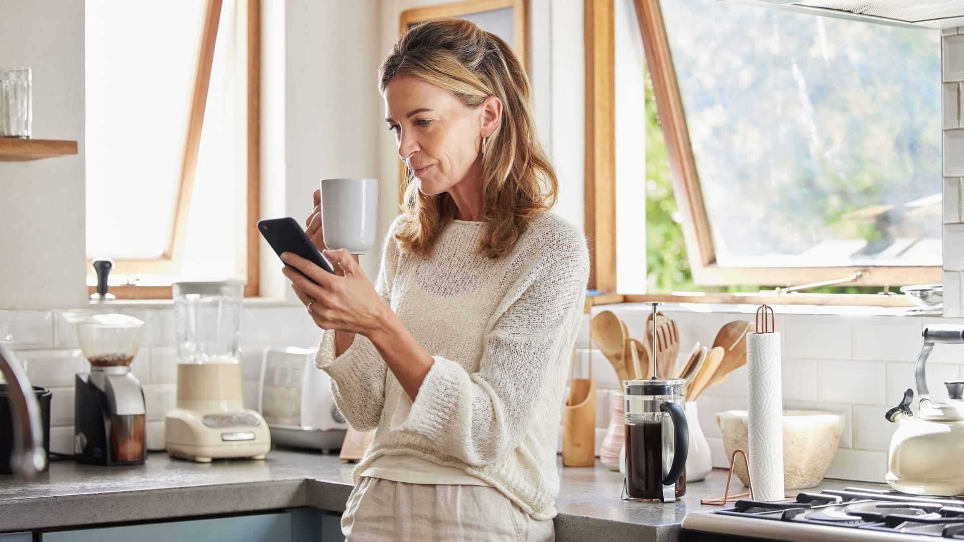 Frau blickt auf ihr Handy. Bis zum Rente fehlen noch einige Jahre.