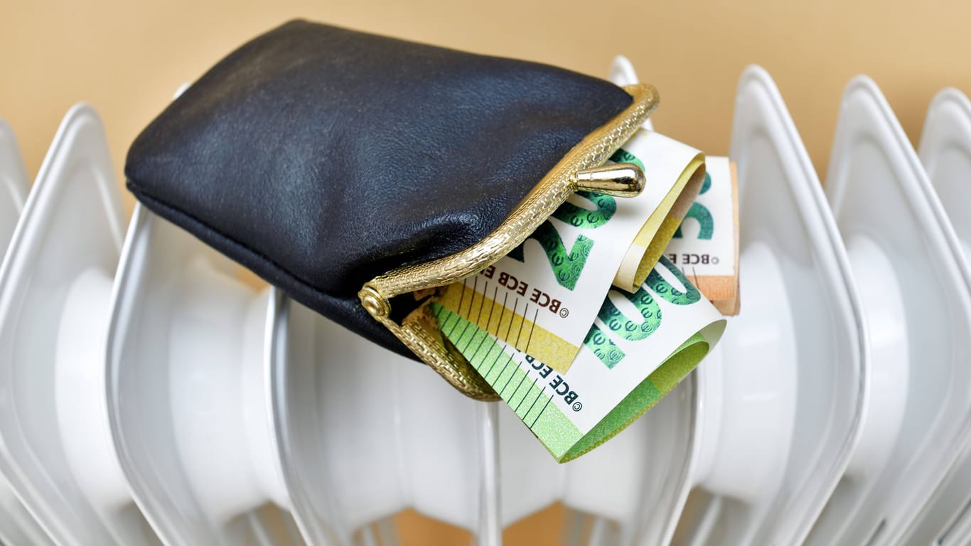 Geldbörse auf einer Heizung (Symbolbild): Unter bestimmten Umständen können Sie den Staat an Ihren Heizkosten beteiligen.