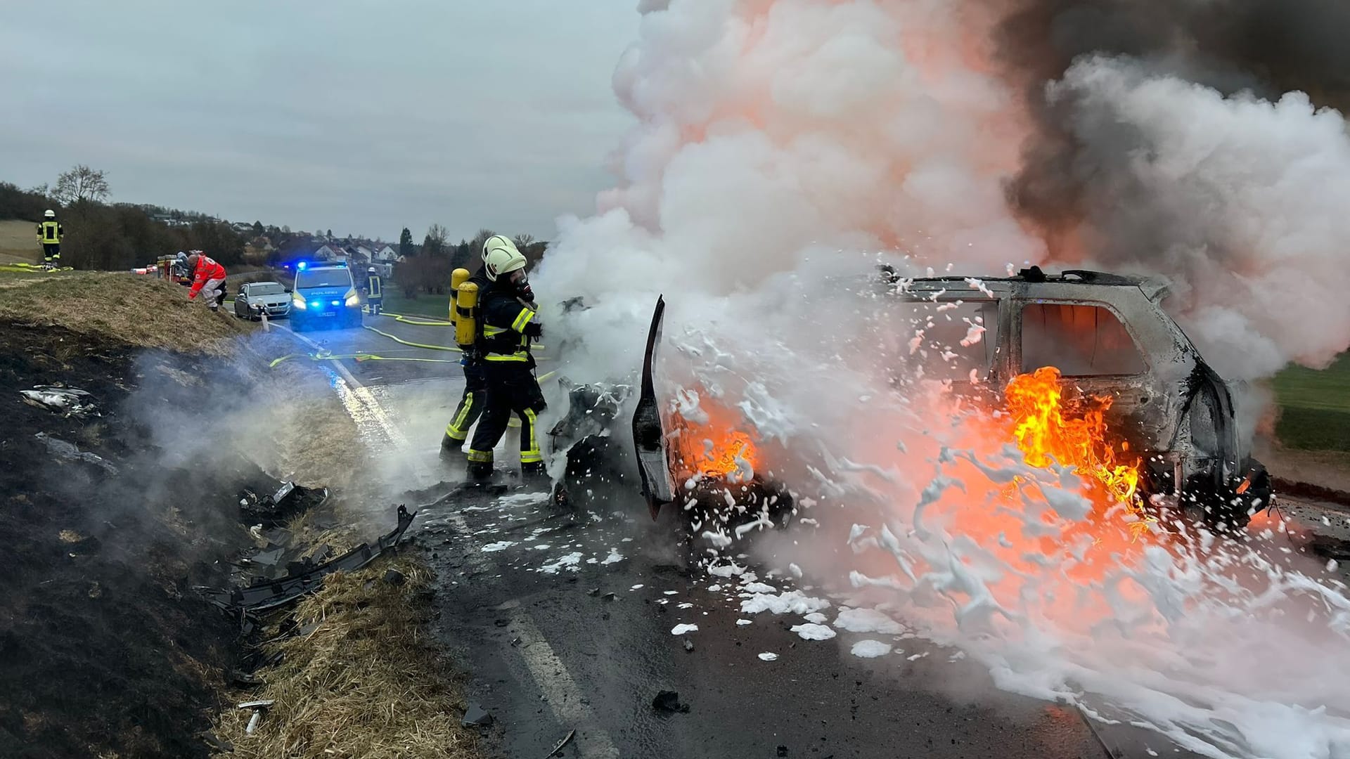 Einsatzkräfte der Feuerwehr löschen brennende Fahrzeuge: Nach einem Unfall im Saarland hatten sie Feuer gefangen.