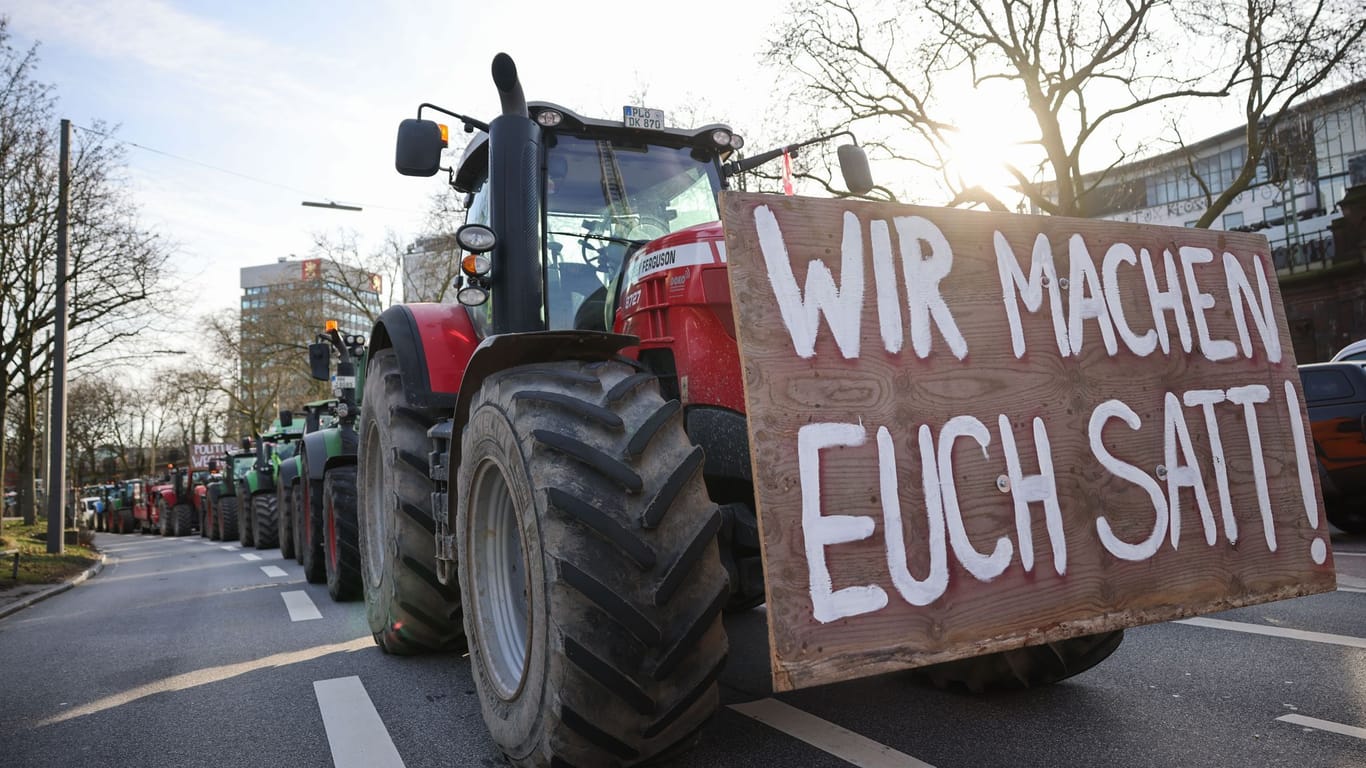 Ein Plakat mit dem Text "Wir machen euch satt!" ist an einem Traktor bei einer Demonstration in Hamburg zu sehen (Archivbild): Die Band unterstützt mit dem Song die Proteste.