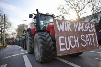 Ein Plakat mit dem Text "Wir machen euch satt!" ist an einem Traktor bei einer Demonstration in Hamburg zu sehen (Archivbild): Die Band unterstützt mit dem Song die Proteste.