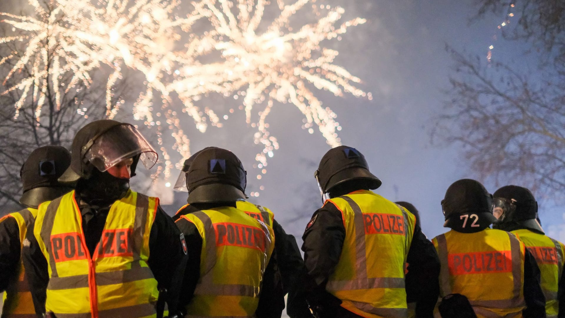 Polizeibeamte stehen vor einem Feuerwerk: Die Zahl der Straftaten gegenüber Einsatzkräften in der Silvesternacht ist noch unbekannt.