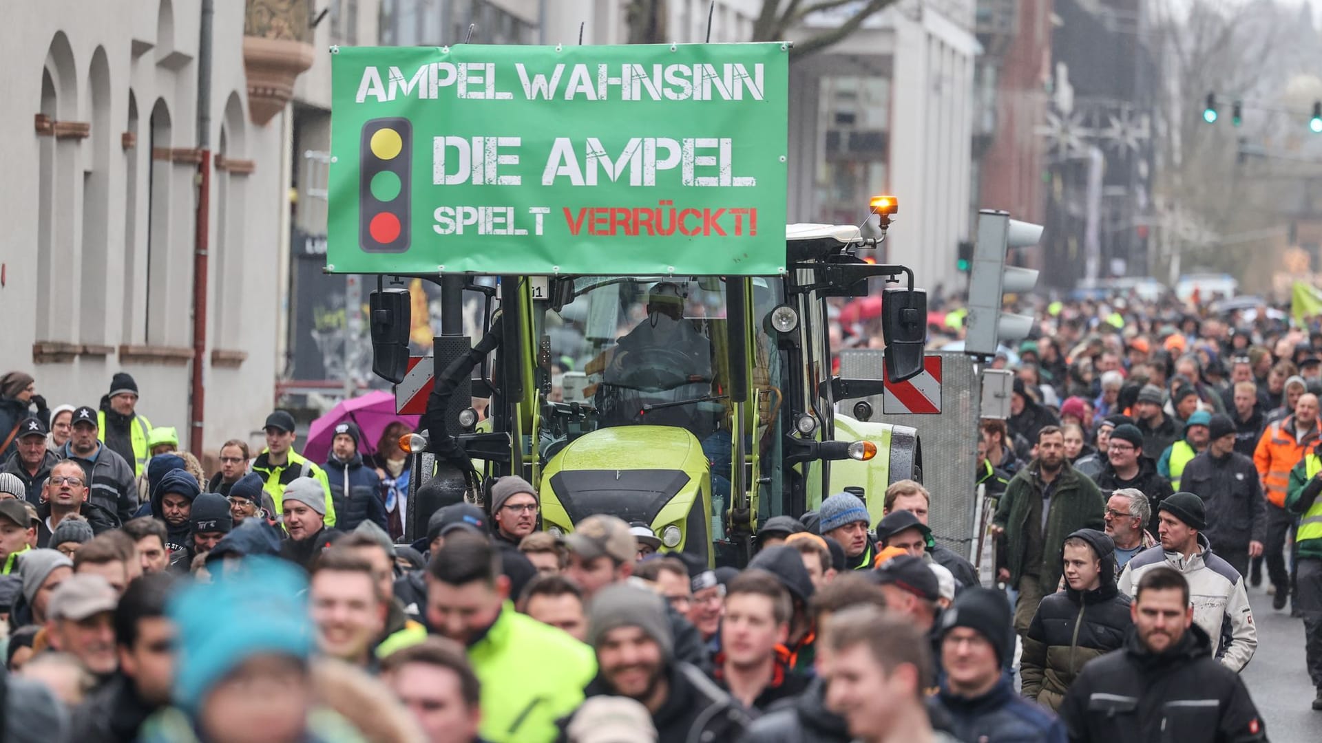 Teilnehmer einer Protestaktion gehen neben einem Traktor: Bundesweit ist zu Blockaden und sogenannten Schleichfahrten aufgerufen worden.