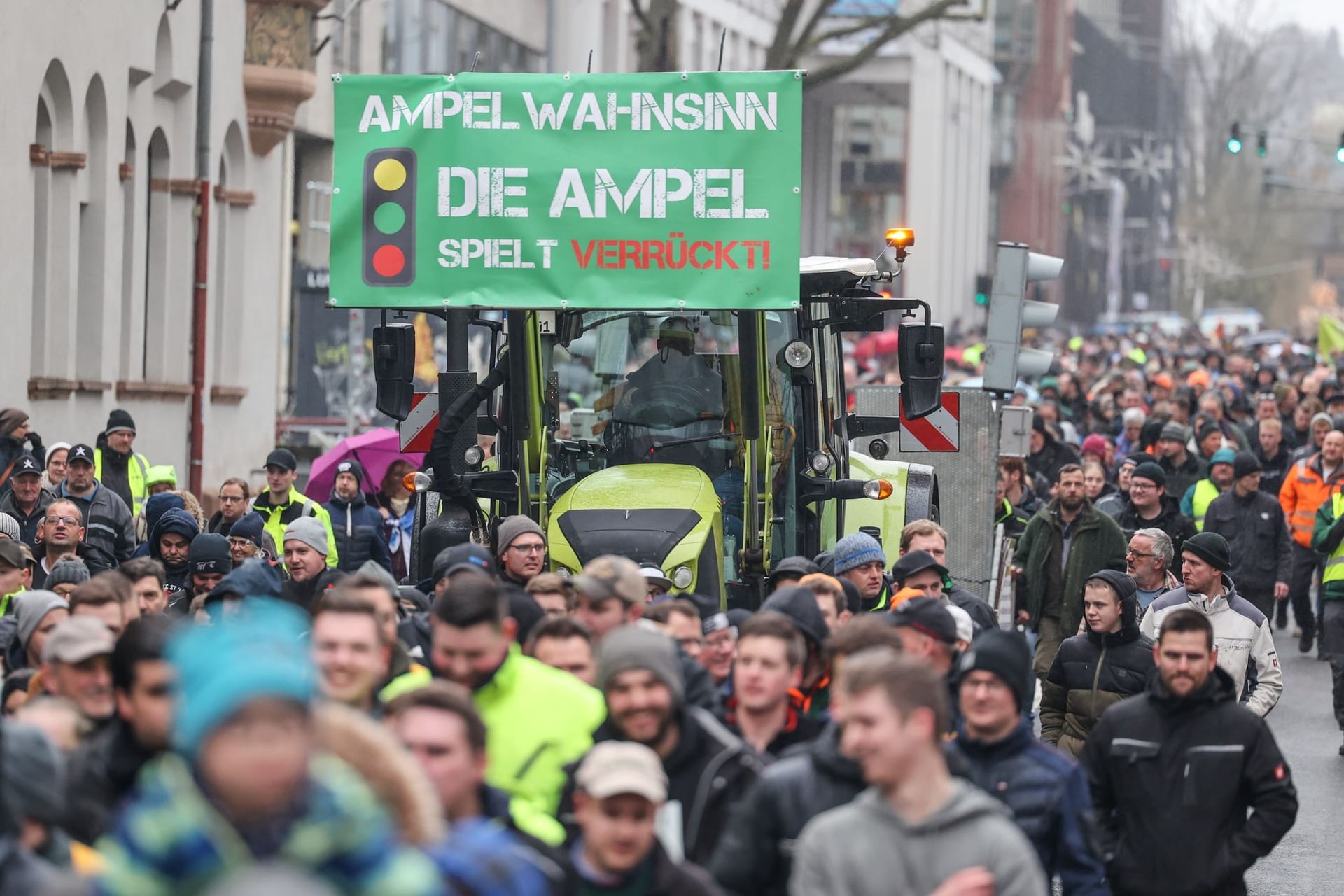 Teilnehmer einer Protestaktion gehen neben einem Traktor: Bundesweit ist zu Blockaden und sogenannten Schleichfahrten aufgerufen worden.