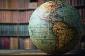 Alter Globus mit Bücherregal im Hintergrund