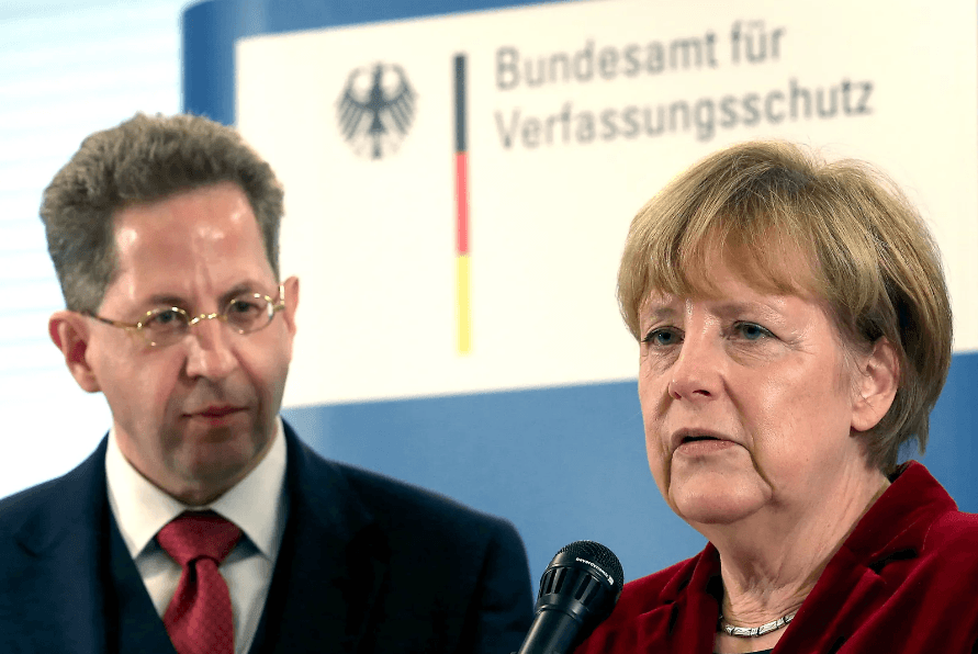 Köln, Deutschland. 31. Oktober 2014. German chancellor Angela Merkel (R) und der Präsident des Bundesamtes für den Schutz der Verfassung (BfV) Hans-Georg Maaßen (L) sprechen in der Geschäftsstelle des BfV in Köln, 31. Oktober 2014