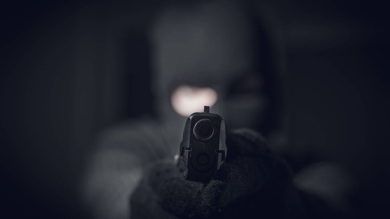 Ein maskierter Mann mit einer Pistole (Symbolbild): Der Täter konnte unerkannt flüchten.