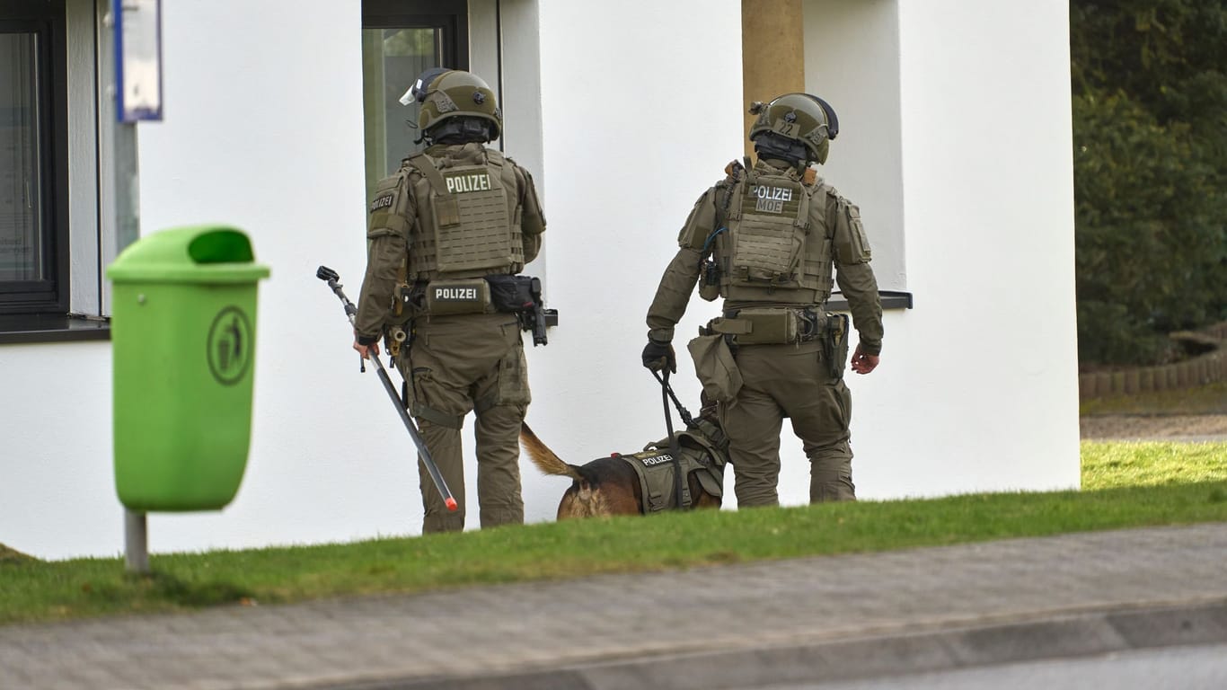 Kurz vor dem Zugriff: Zwei SEK-Beamte stehen mit einem Hund vor einem Wohngebäude.