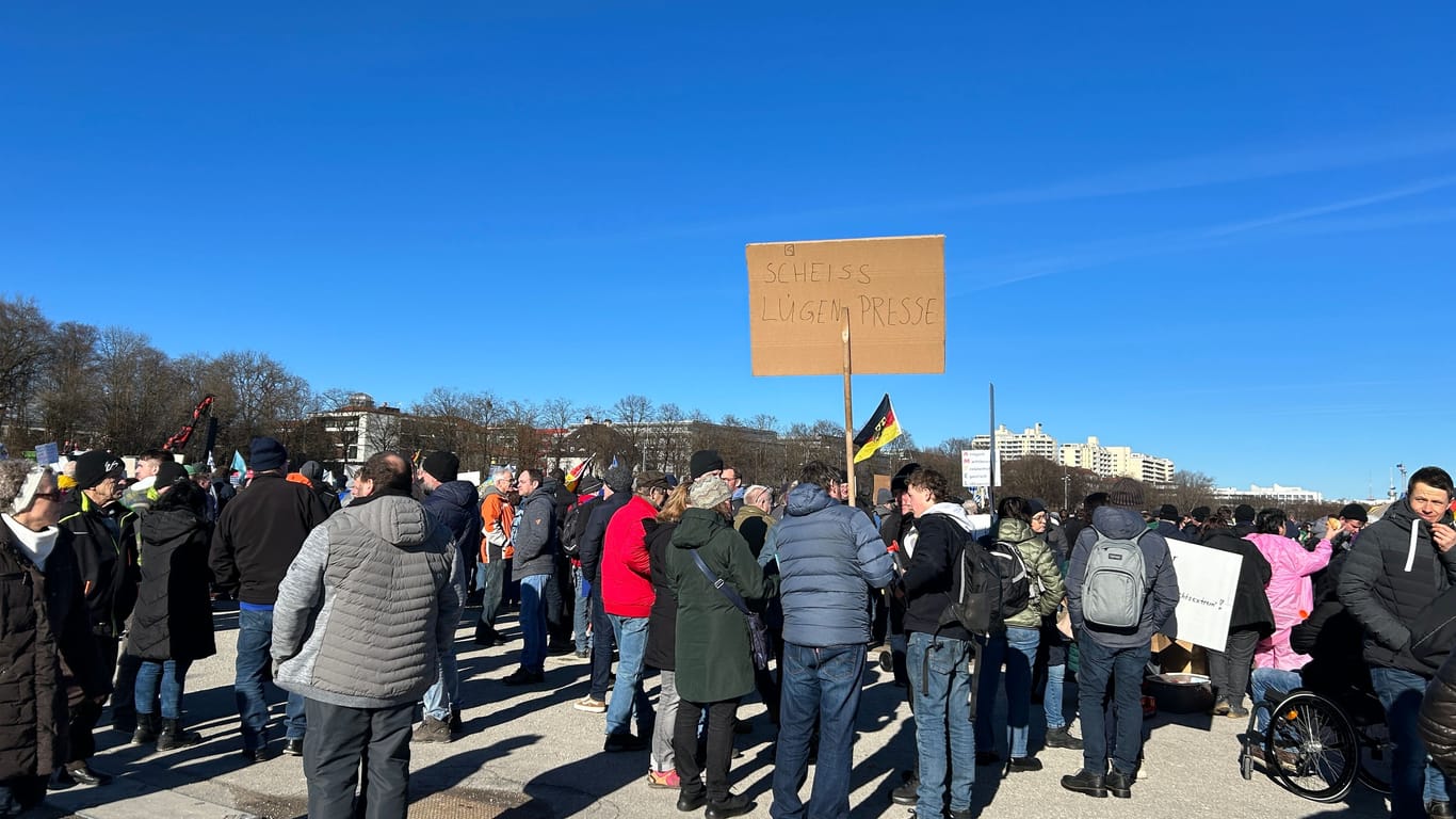 Eine Gruppe von Demo-Teilnehmern hält ein Schild mit den Worten "Scheiss Lügenpresse" hoch.