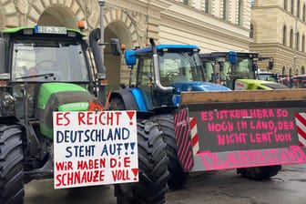 Auftakt der deutschlandweiten Aktionswoche in München: Bauern machen mit Schildern an ihren Traktoren ihrem Unmut Luft.