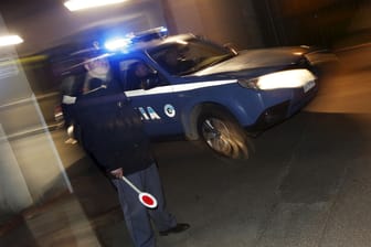 Polizist vor Polizeiauto in Italien (Symbolbild): Gegen eine Mutter wird wegen mutmaßlicher Ermordung ihrer Tochter ermittelt.