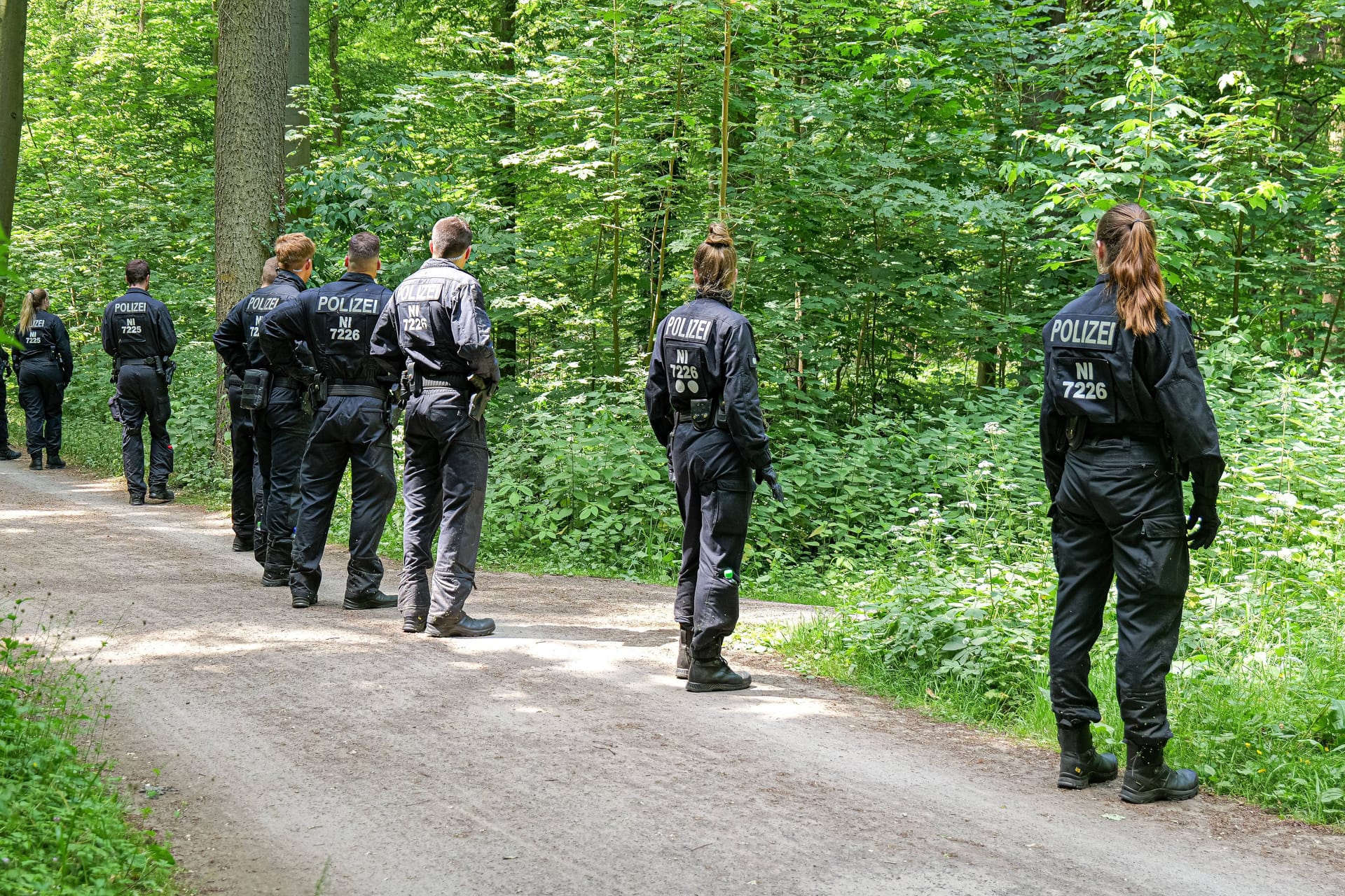 Beamte suchen einen Wald ab (Symbolbild): Funkzellendaten brachten die Ermittler auf die Spur der Vermissten.