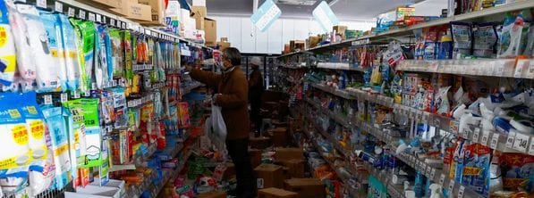 Menschen nehmen nach dem Erdbeben Artikel aus den Regalen einer beschädigten Drogerie in Anamizu, nachdem ihnen der Besitzer die Erlaubnis erteilt hat, die Waren kostenlos mitzunehmen.