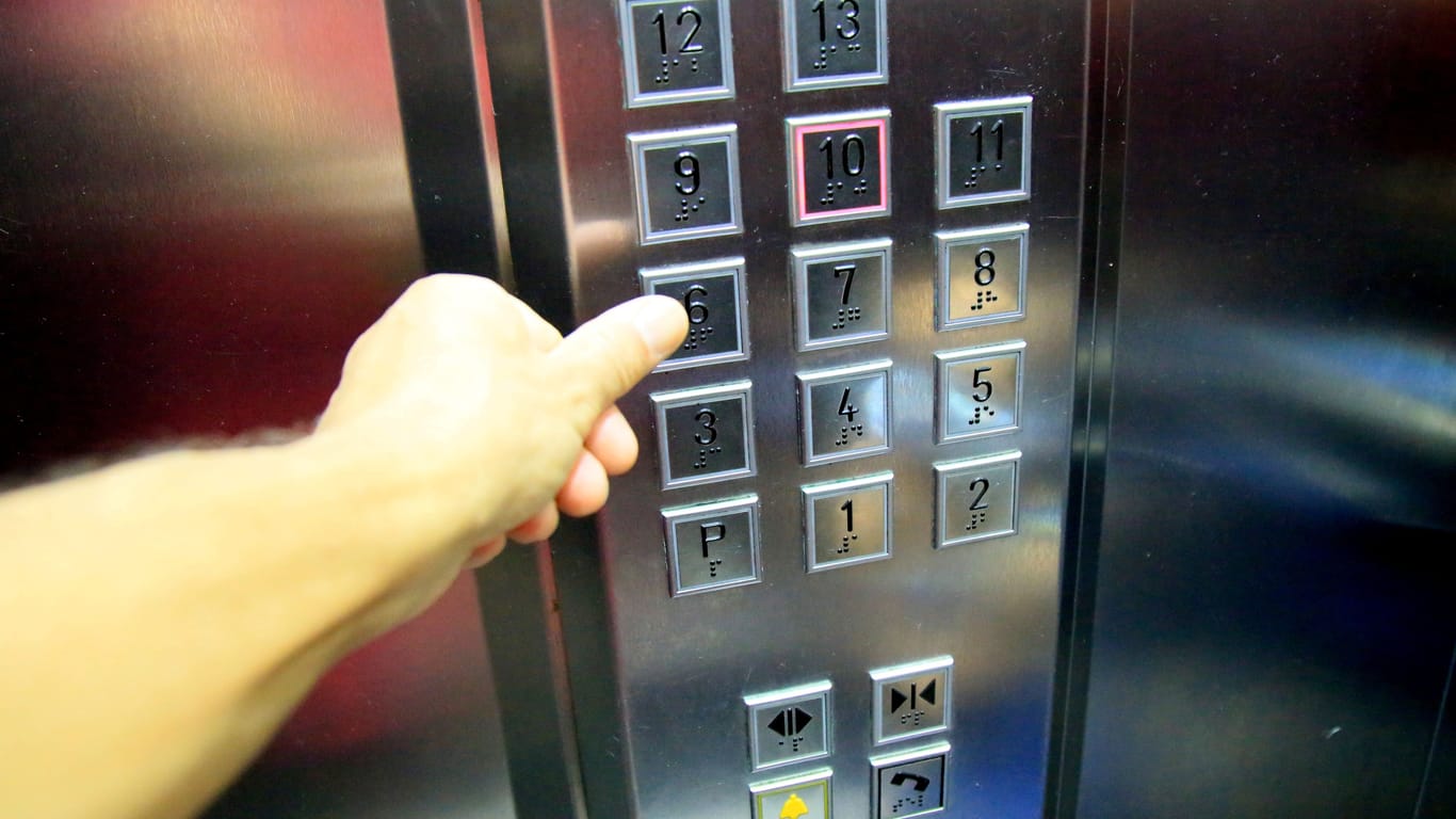 Ein Mann drückt einen Knopf in einem Aufzug (Symbolbild): Erst nach zwei Stunden konnte der Eingesperrte befreit werden.