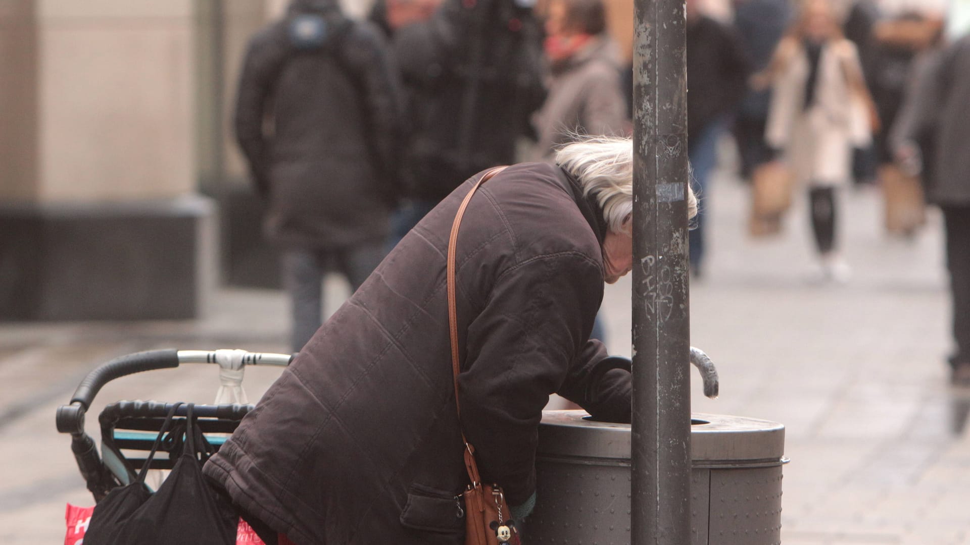 (Symbolfoto) Eine Flaschensammlerin sucht nach pfandpflichtigem Leergut in der Münchner Innenstadt.