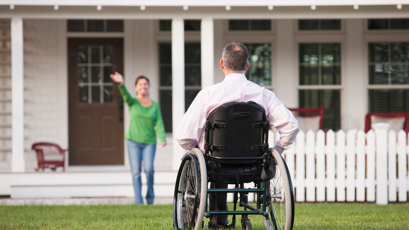 Mann im Rollstuhl vor seinem Haus
