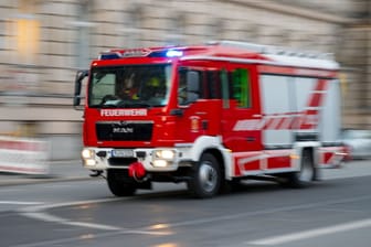 Ein Feuerwehrfahrzeug ist mit Blaulicht auf Einsatzfahrt (Symbolfoto): In München wurde eine Frau aus ihrer Wohnung gerettet.