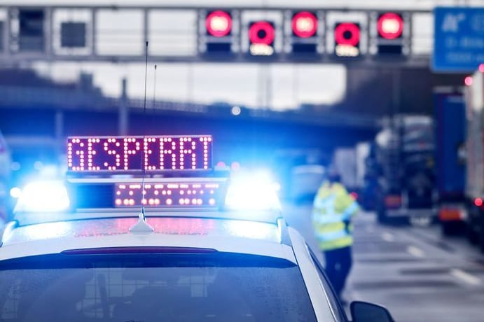 Auf einem Polizeifahrzeug leuchtet die Aufschrift "Gesperrt" (Symbolbild): Auf der A7 liegt der Verkehr in Richtung Norden vorerst lahm.