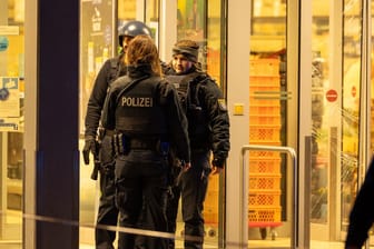 Beamte stehen vor einem Supermarkt im hessischen Mörfelden-Walldorf: Dort wurde am Abend eine Frau erschossen.