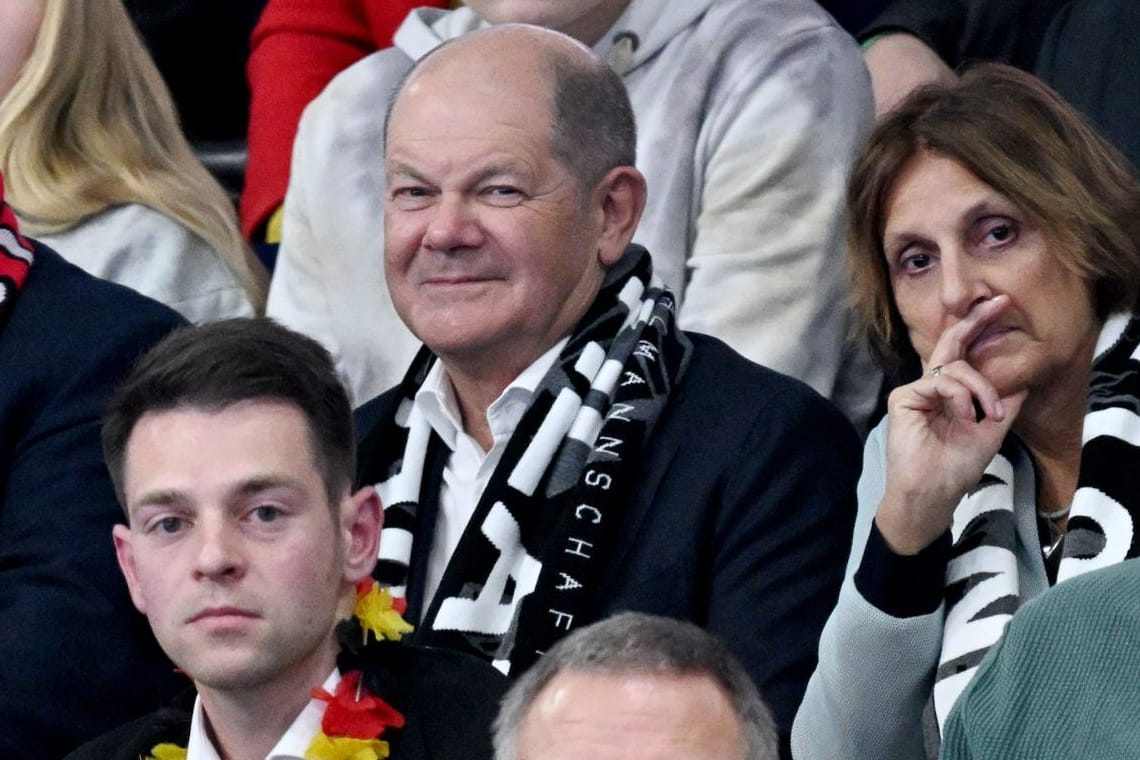 Bundeskanzler Olaf Scholz (M./SPD), seine Frau Britta Ernst (r.) bei der Handball-EM in der Berliner Mercedes-Benz-Arena.