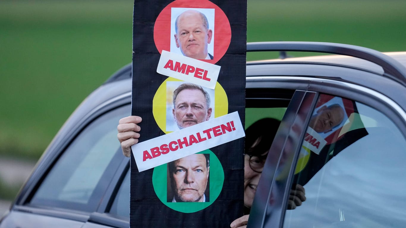 Eine Demonstrantin hält ein Schild mit den Gesichtern von Olaf Scholz, Christian Lindner und Robert Habeck: FDP-Wähler gehen deutlich eher von vorgezogenen Neuwahlen aus als Wähler von SPD und Grünen.