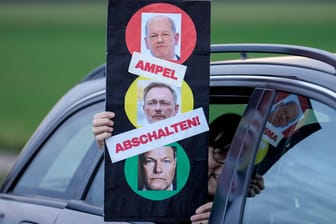 Eine Demonstrantin hält ein Schild mit den Gesichtern von Olaf Scholz, Christian Lindner und Robert Habeck: FDP-Wähler gehen deutlich eher von vorgezogenen Neuwahlen aus als Wähler von SPD und Grünen.