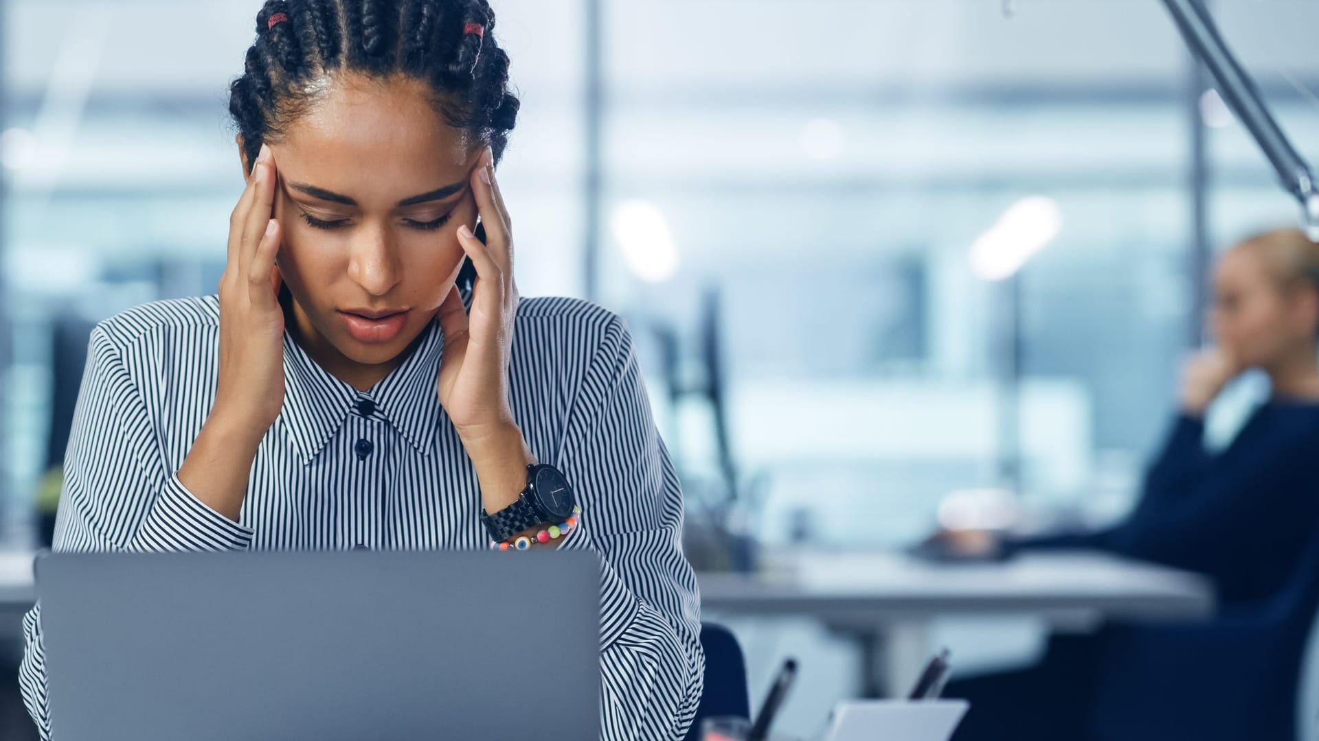 Frau im Büro massiert sich die Schläfen