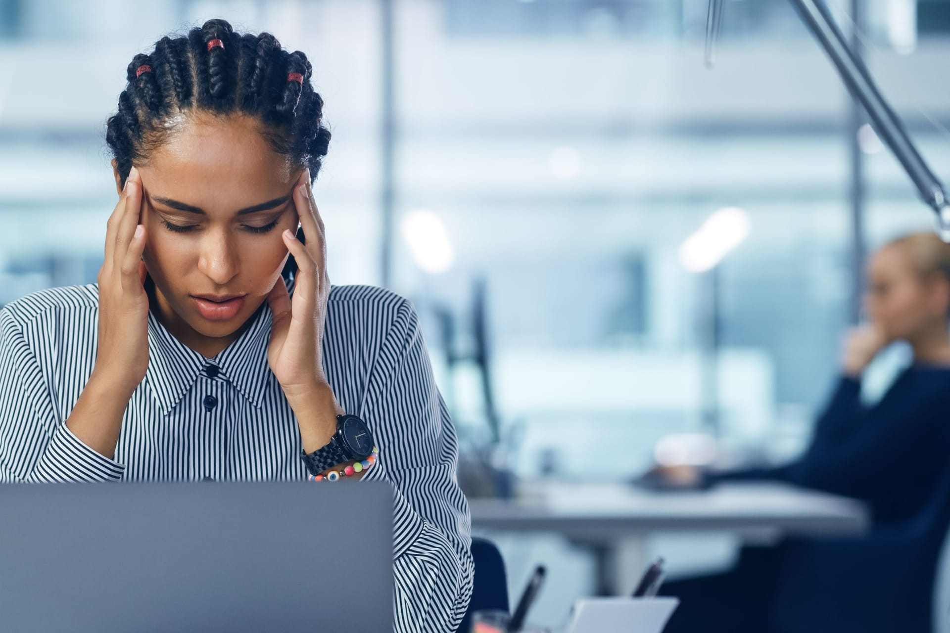 Frau im Büro massiert sich die Schläfen