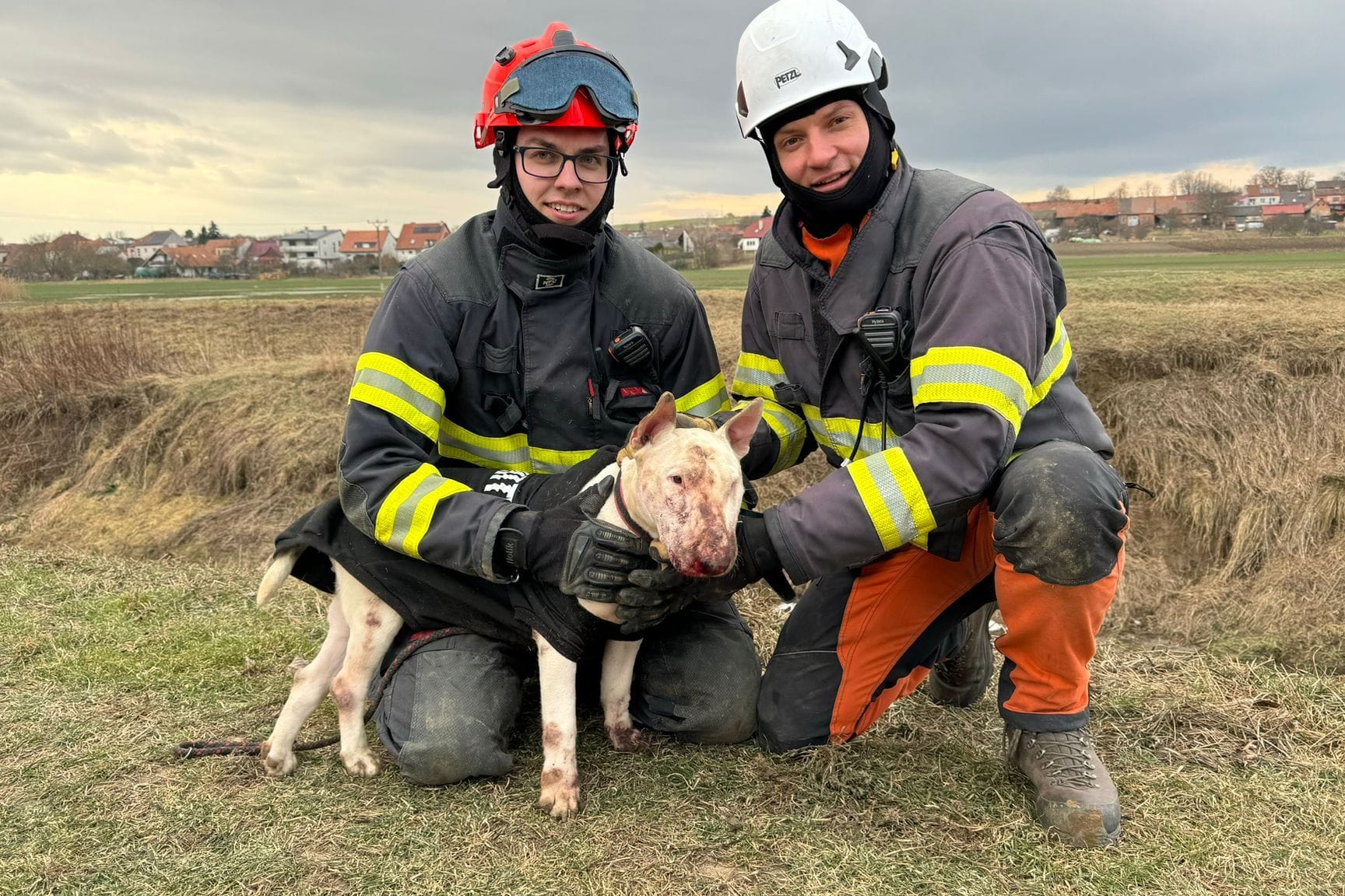 Zwei Feuerwehrleute aus der Region Südmähren mit einem Terrier in den Händen: Dieser wurde von Nutrias attackiert, nachdem er in ihr Bau geschlüpft war.