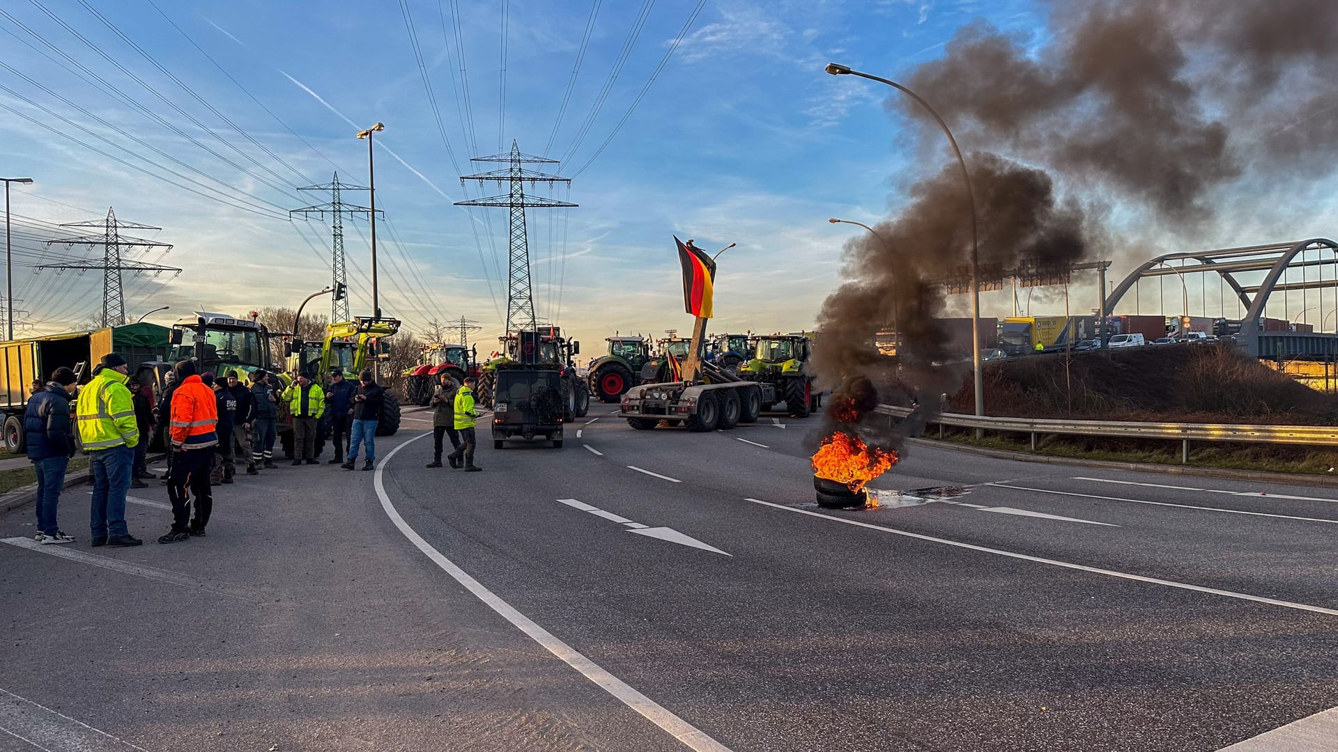 Einer Feuertonne brennt auf der Straße: Die Proteste der Bauern bringen den Verkehr in Hamburg an mehreren Stellen zum Stillstand.