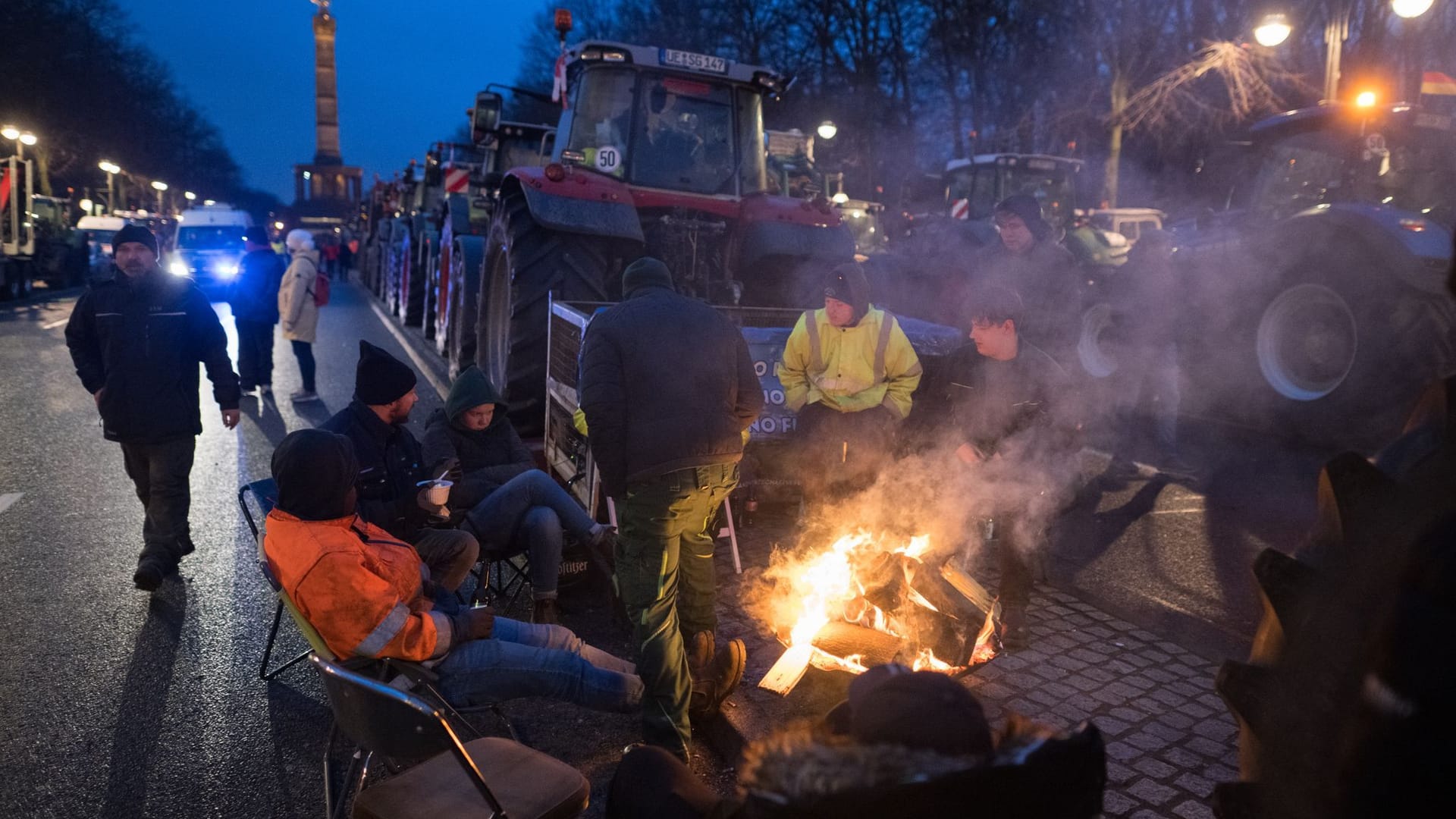 Männer sitzen vor der angekündigten Großdemonstration des Deutschen Bauernverbandes am Brandenburger Tor: In der gesamten Stadt kommt es zu Verkehrsbeeinträchtigungen.