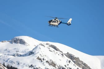 Ein Hubschrauber der Polizei fliegt nach einem Lawinenabgang über den Bergen: Für den Verunglückten kam jede Hilfe zu spät