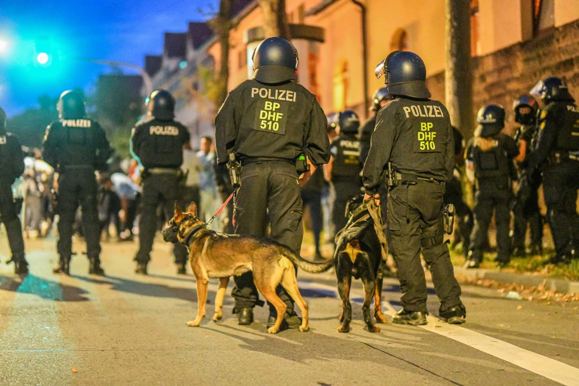 Einsatzkräfte der Polizei stehen mit Hunden nach Ausschreitungen bei einer Eritrea-Veranstaltung in Stuttgart auf der Straße (Archivfoto).