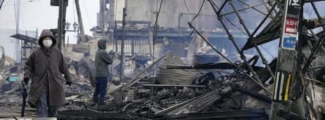 Eine Frau geht durch einen vom Feuer und Erdbeben besonders stark betroffen Teil von Wajima. Wie die japanische Zeitung "Mainichi Shimbun" berichtet, stammen 19 der 48 bis jetzt bestätigten Toten aus der japanischen Hafenstadt.