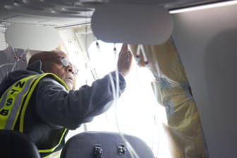 Ein Mitarbeiter der amerikanischen Verkehrsbehörde NTSB untersucht die Stelle, an der die Tür der Boeing 737 Max 9 aus der Hülle gerissen wurde.