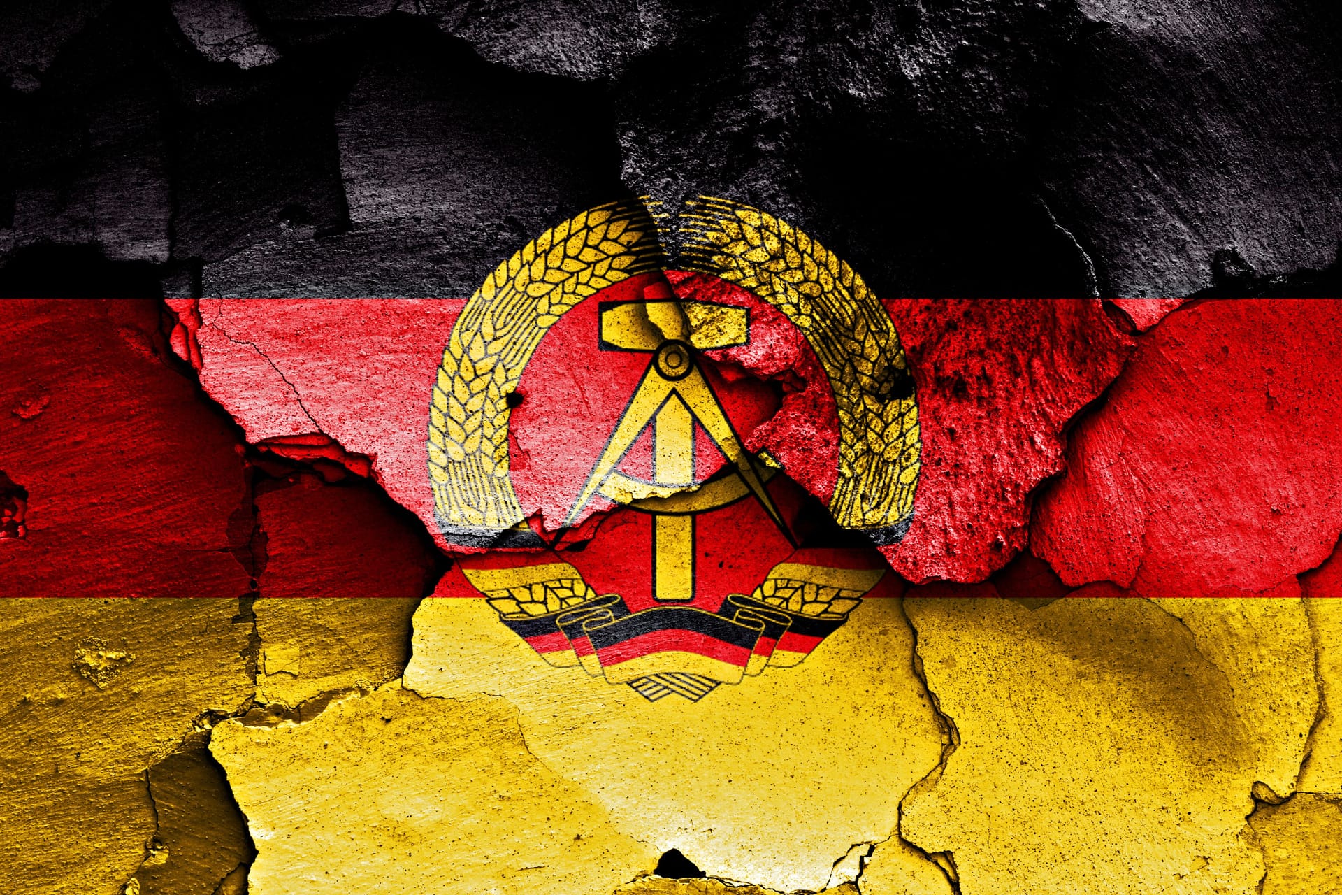 Die Flagge der DDR gemalt auf einer kaputten Wand