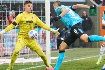 Drückend überlegen: Leverkusens Andrich (r.) scheitert an Augsburgs Torwart Dahmen.