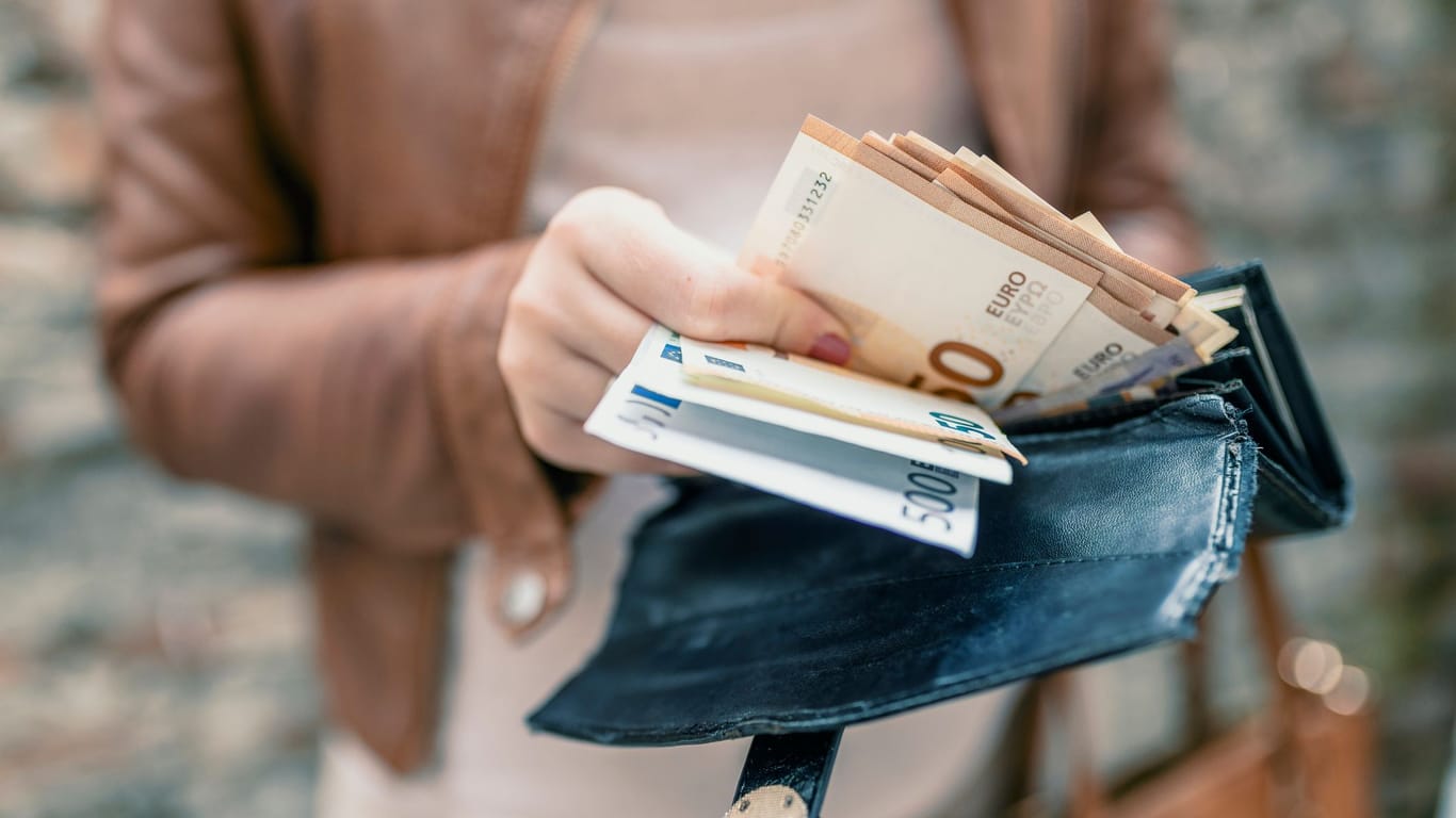 Eine Frau hält Geldscheine (Symbolbild): Für Anspruchsberechtigte gibt es auf Antrag bis zu 292 Euro im Monat.