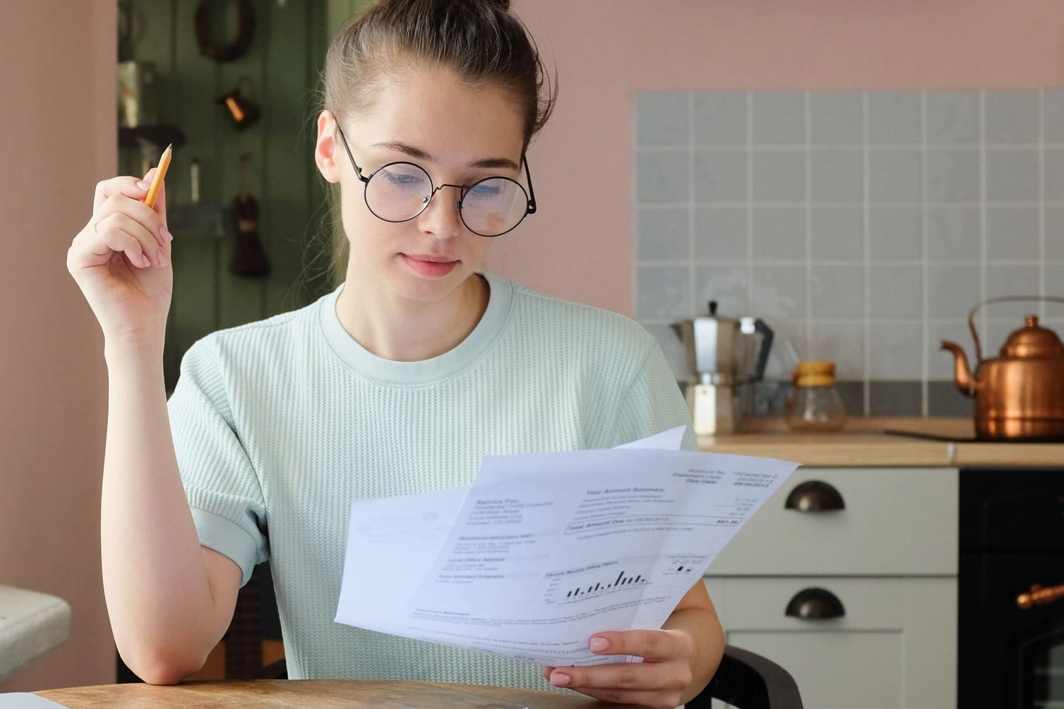 Junge Frau prüft Dokumente (Symbolbild): Wer noch viel Zeit hat, für die Rente zu sparen, kann auf den Aktienmarkt setzen.