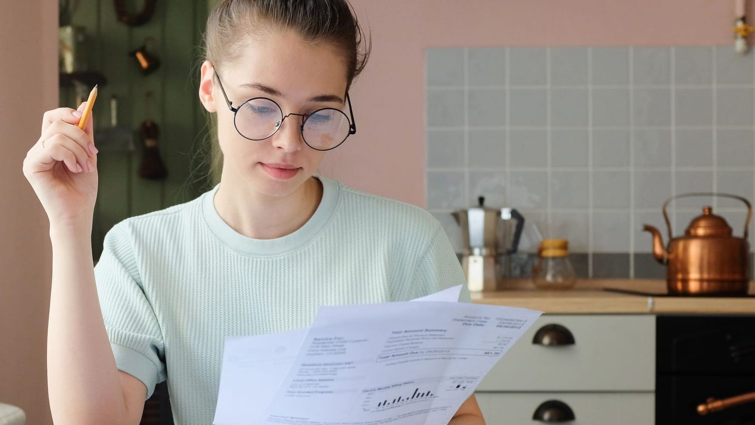 Junge Frau prüft Dokumente (Symbolbild): Wer noch viel Zeit hat, für die Rente zu sparen, kann auf den Aktienmarkt setzen.