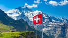 Schweizer Berge im Sommer bei strahlendem Sonnenschein mit wehender Schweizer Nationalflagge