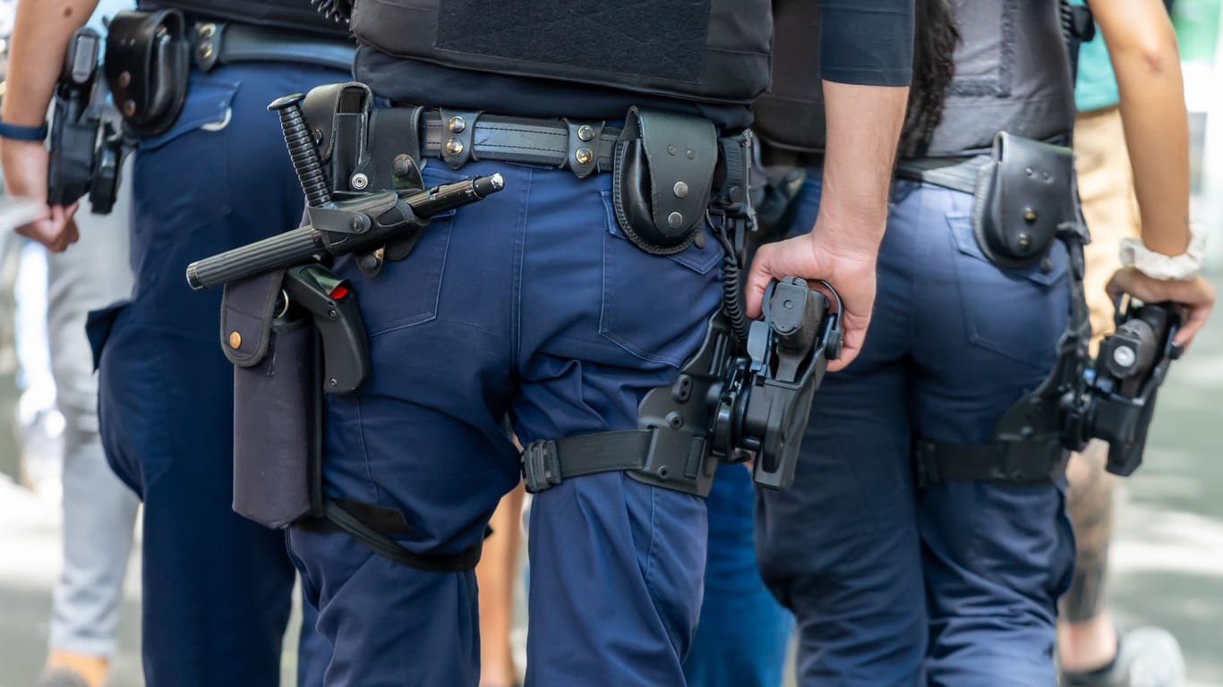 Die Rückenansicht von Polizisten: In Berlin wurden zwei Wohnungen eines 20-jährigen Mannes durchsucht, der eine Polizistin in der Silvesternacht geschlagen haben soll.