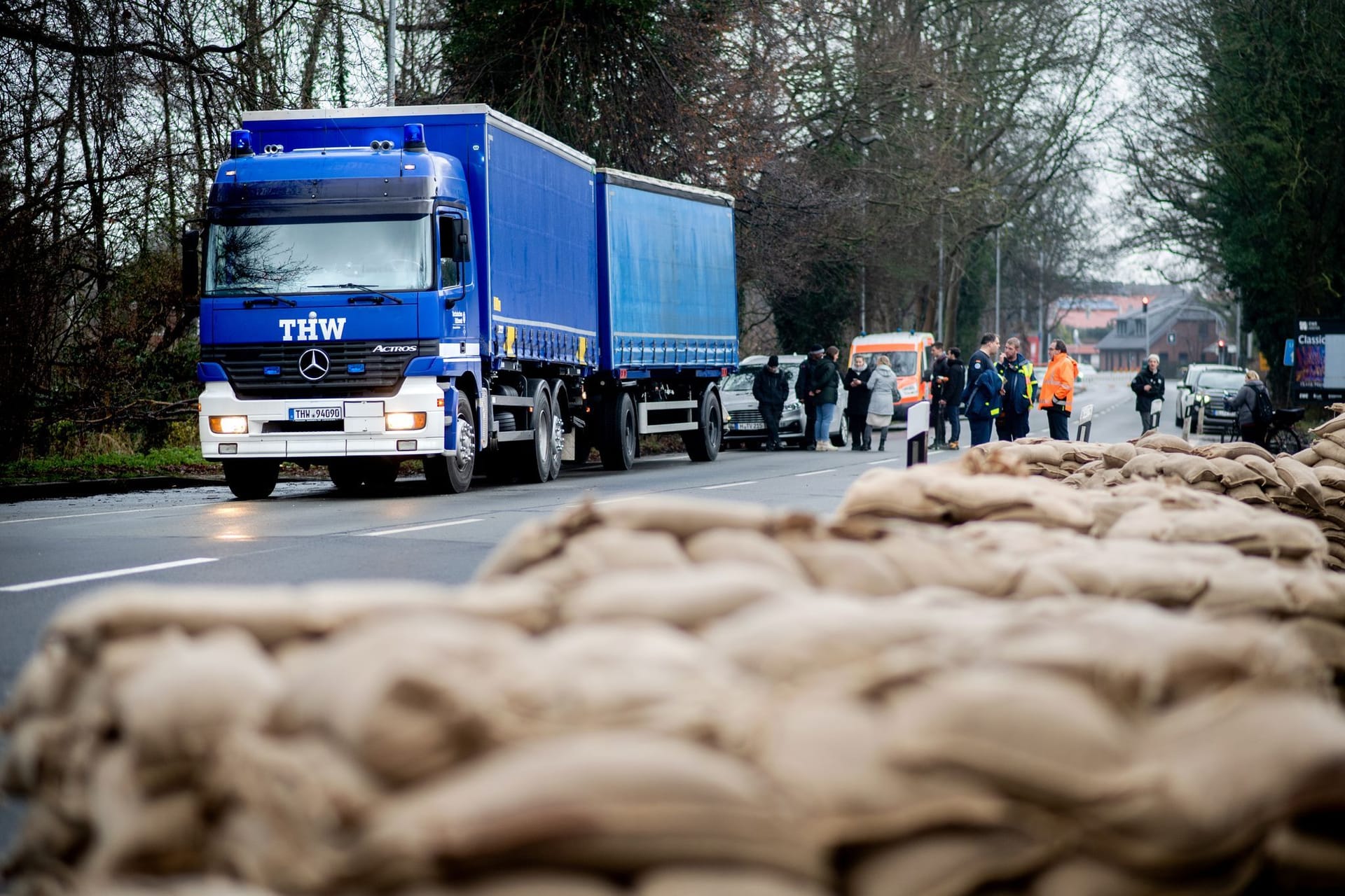 Einsatzkräfte des Technischen Hilfswerks (THW) sind im Einsatz, um ein Wohnhaus am Osternburger Kanal vor dem drohenden Hochwasser mit Sandsäcken zu sichern.