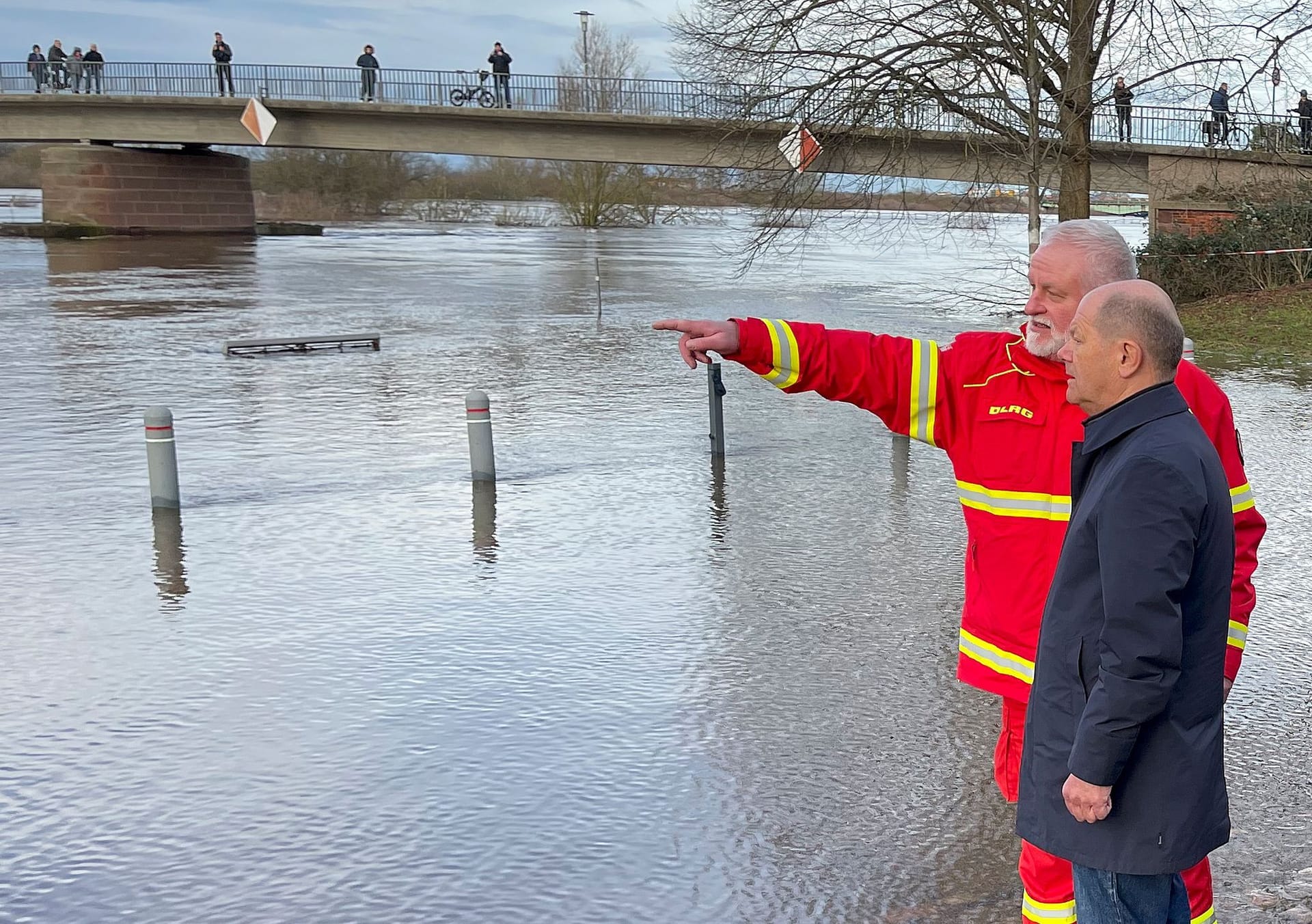 Bundeskanzler Olaf Scholz (SPD) unterhält sich im Flutgebiet mit Karsten Hauschild vom DLRG. Scholz hat sich per Rundflug mit einem Helikopter der Luftwaffe einen Eindruck über die Hochwasserlage im Norden Niedersachsens verschafft.