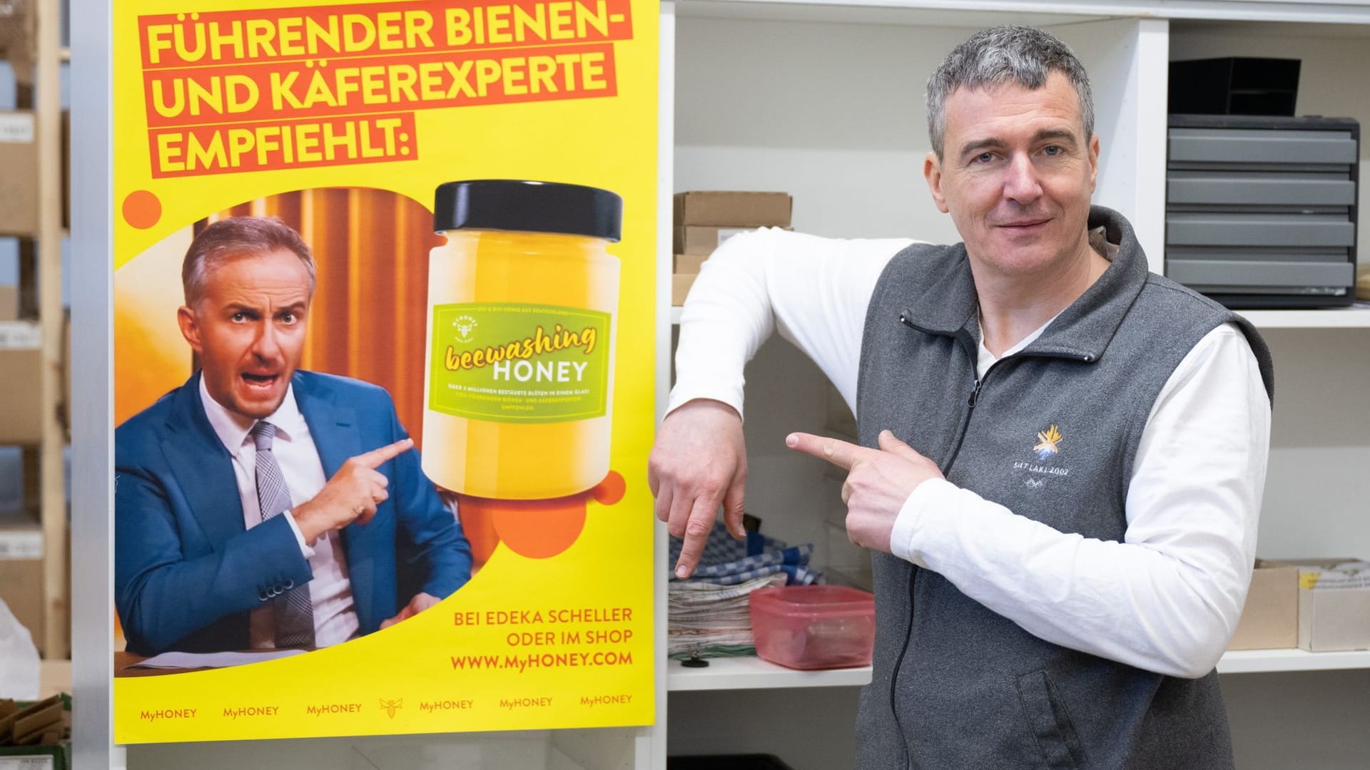 Rico Heinzig, Imker, steht neben einem Plakat mit dem Foto des Moderators Jan Böhmermann. Böhmermann verklagt den Imker auf 20.000 Euro, weil er ungefragt sein Bild und seinen Namen genutzt hat.