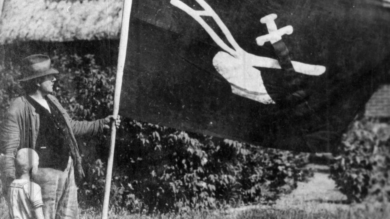 Ein Bauer lässt die Fahne der Landvolkbewegung wehen (Archivbild): Ab 1929 war die schwarze Fahne mit Pflug und Schwert ein Symbol der völkischen und antisemitischen Bewegung.